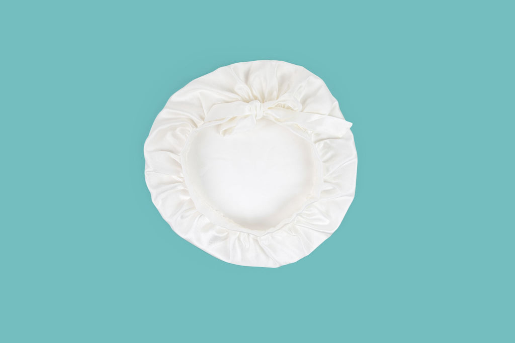Ameline Ava Pearly White lustrious 100% Mulberry Silk Hair Bonnet, against blue background