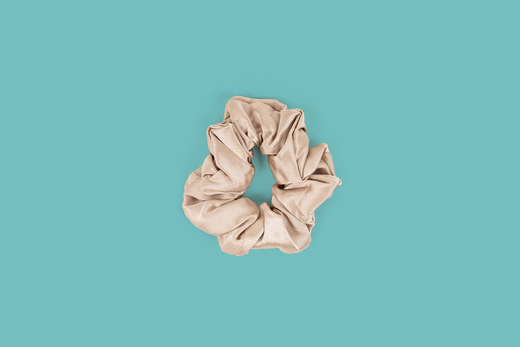 Ameline Ava Beige lustrious 100% Mulberry Silk Thick Scrunchie, against blue background