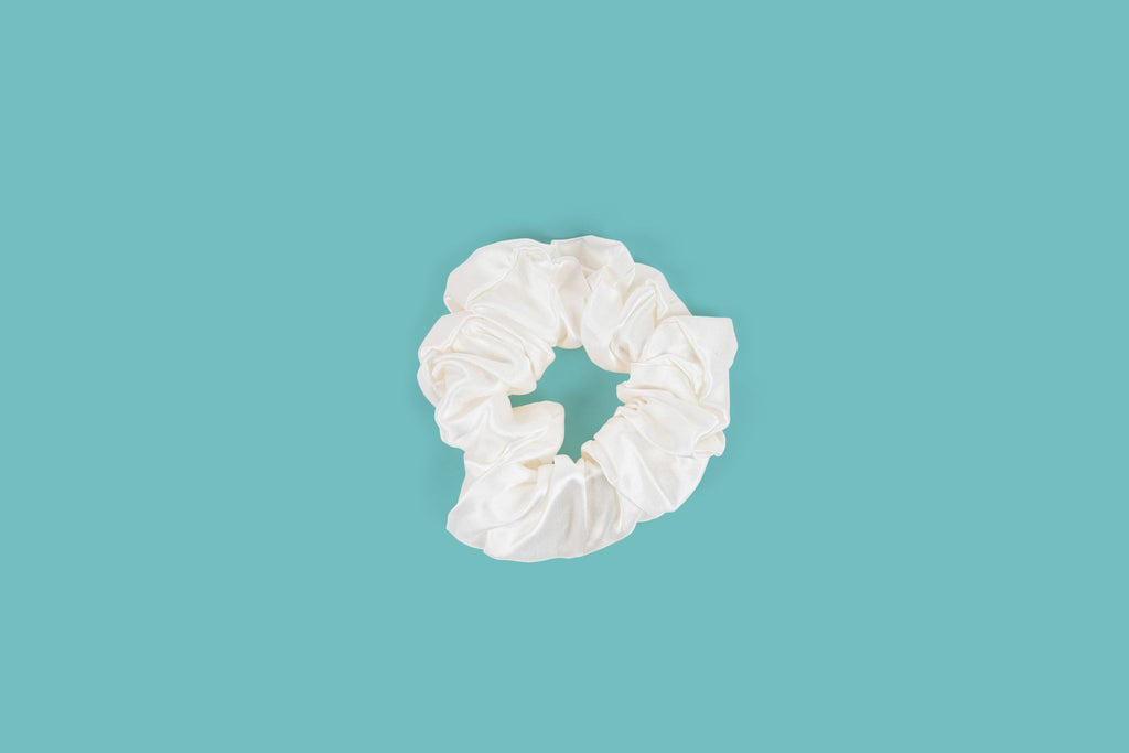 Ameline Ava Pearly White lustrious 100% Mulberry Silk Thick Scrunchie, against blue background